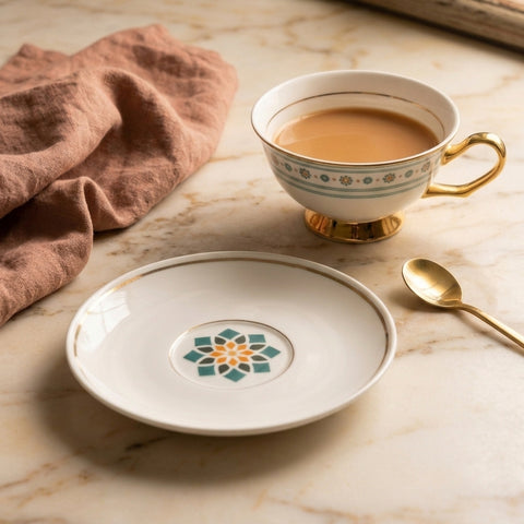 Teacup with saucer and spoon on a marble surface