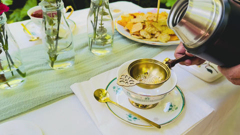 A Video Of Tea being strained using a Brass Tea Strainer over a ceramic cup.