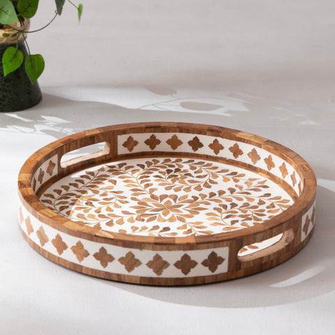 Decorative wooden tray with intricate patterns on a white surface