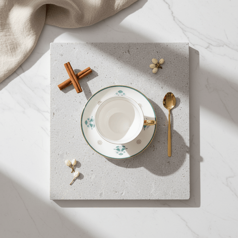 Bone china cup and saucer set shown with the gold-plated stainless steel spoon