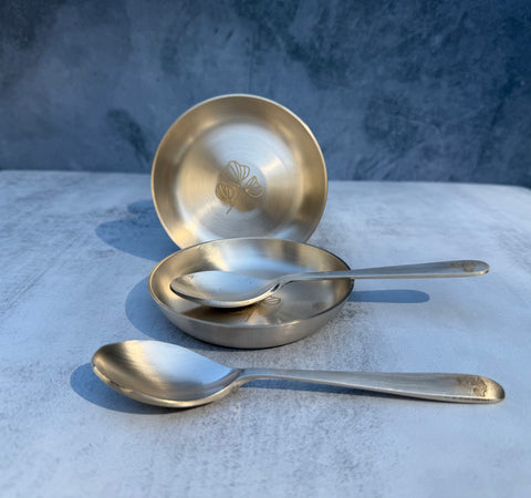 Kansa dessert bowl set with engraved floral motif and matching spoons side by side
