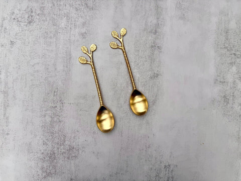 Brass cutlery dessert spoon showing the detailed leaf handle in golden brass