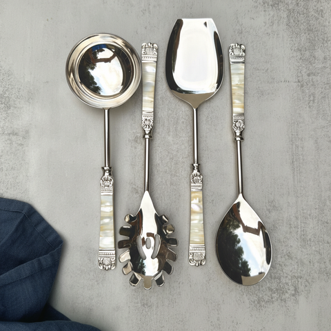 Set of stainless steel decorative serving Spoon Set with pearl inlays on a textured gray surface