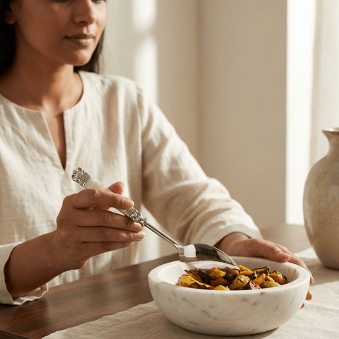 Woman eating from a bowl of food using a stainless steel serving Spoon with mother of pearl inlays.