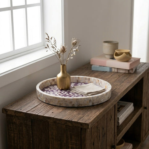 Decorative tray with a vase and books on a wooden surface near a window