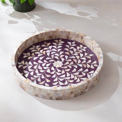 Round decorative tray with a purple and white pattern on a light surface