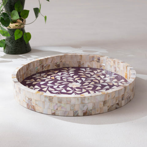 Round mosaic tray with a decorative pattern on a white surface