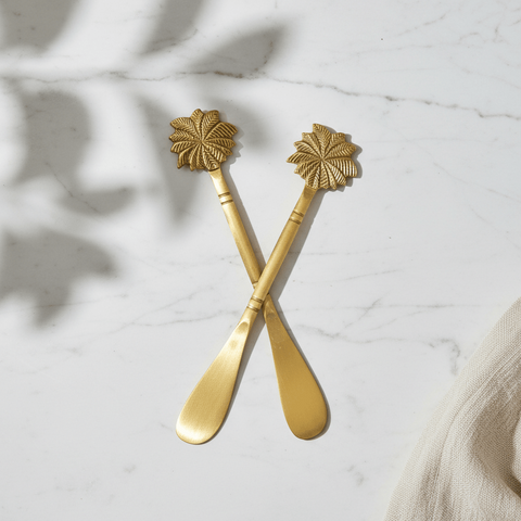 Brass butter knife set  with palm-tree handles with decorative handles on a marble surface