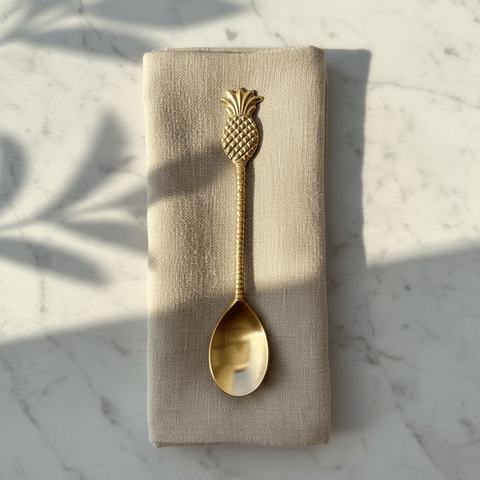 Brass spoon showing the intricate pineapple-shaped handle in golden brass