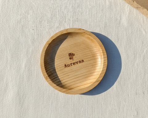 Wooden bowl with 'Aurevaa' branding on a textured surface