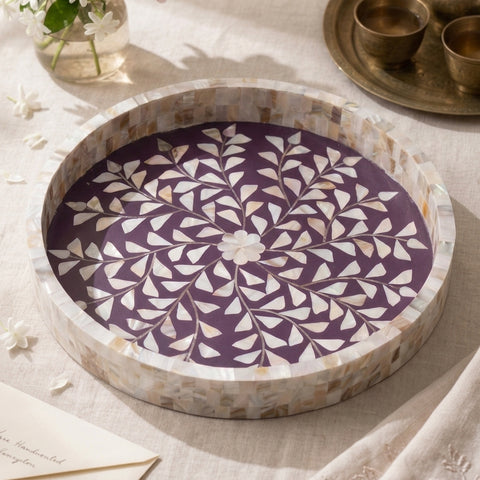 A violet round tray with mother of pearl inlay on a light surface